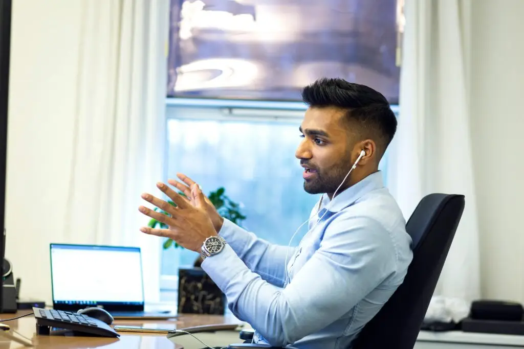business man sitting at his desk talking in headphone